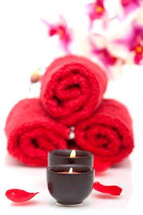 Meditation candle with red towels and rose petals
