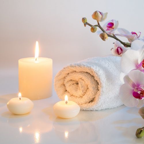 preparation for bath in white with towels, candles and orchid